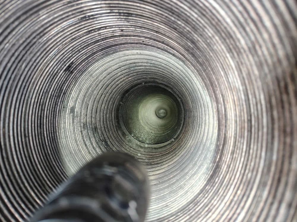 Close-up view inside a circular pipe showing textured walls and a dimly lit interior.